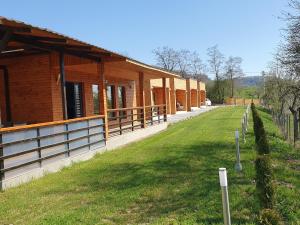 a building with a grass field in front of it at LiAn House in Corbeni