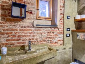 a bathroom with a sink and a brick wall at lovingenoa Light - Passion in Genoa +17 photos