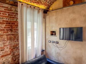 a living room with a couch and a television on a wall at lovingenoa Light - Passion in Genoa