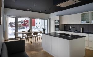 a kitchen with a sink and a table with chairs at North Estate City House in Tromsø