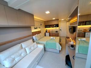 a living room with a couch and a bed at Nixxus Luxo e requinte á 50 m do mar e próximo as piscinas Naturais in Porto De Galinhas