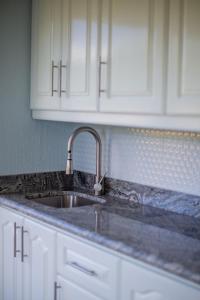 a kitchen counter with a sink and white cabinets at Romantic 1BR Studio Guesthouse with 3 Shared Pools, Beach and Resort Access in Ocotal
