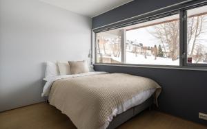 a bedroom with a bed and a window at North Estate City House in Tromsø