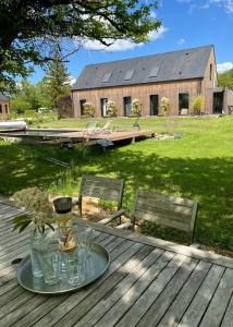 a table with glasses on it with a house in the background at Les Caminols in La Dornac