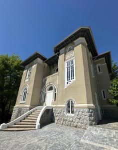 a large building with stairs in front of it at Vila Doctor Popovici in Prăjila