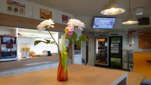 a vase filled with flowers sitting on top of a table at hotelF1 Evreux Sud in Évreux