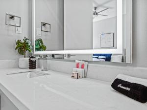 un bagno con un lavandino e un grande specchio di Stunning New Modern Magnolia Townhome a Fort Worth Altre 32 foto
