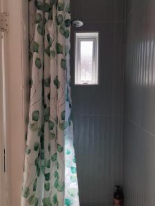 - un rideau de douche dans la salle de bains pourvue d'une fenêtre dans l'établissement Cosy Cork - House - Sleeps 4 - City Centre, à Cork 13 autres photos