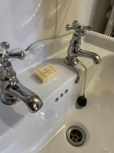 a bathroom sink with a faucet and a bar of soap at The Plume of Feathers in Farnham
