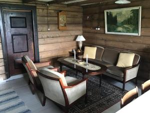 a living room with a couch and a table and chairs at Gamlemgarden by Norgesbooking - house by the sea in Longva