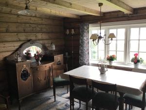 a dining room with a table and some windows at Gamlemgarden by Norgesbooking - house by the sea in Longva