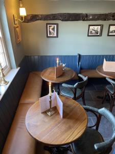 two tables in a restaurant with candles on them at The Plume of Feathers in Farnham