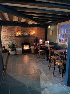 a restaurant with a fireplace and tables and chairs at The Plume of Feathers in Farnham