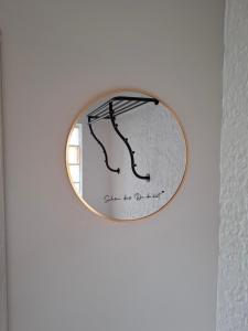 a round mirror with a picture of a tree on a wall at Ferienhaus Ewergass in Mertesdorf - nur 8 km von Trier - kostenloses ÖPNV-Ticket inklusive in Mertesdorf