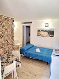 a bedroom with a blue bed and a table at Nata Sicula in Syracuse