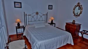 1 dormitorio con 1 cama, 2 lámparas y espejo en Casa Guinea, en La Frontera
