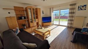 a living room with a couch and a tv at Urlaub am Sonnenhügl in Rinchnach +18 photos