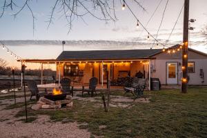a backyard with a fire pit and a house with lights at River Front Get Away in Brownwood