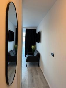 a mirror in a room with a couch and a chair at Atlantic 003- Exclusive Ferienwohnung mit Pool, Sauna und Fitnessbereich im Haus in Cuxhaven