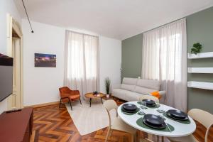 un soggiorno con divano bianco, tavolo e sedie di 5 minutes from Via Roma - with Smart TV a Torino