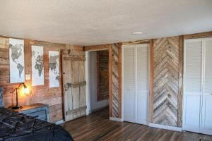 a bedroom with wooden walls and a bed and two doors at River Front Get Away in Brownwood