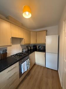 a kitchen with a stove and a white refrigerator at The Lakes in Stockingford +13 photos