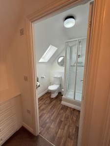 a bathroom with a toilet and a glass door at The Lakes in Stockingford