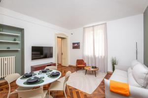 un soggiorno con un tavolo e un divano di 5 minutes from Via Roma - with Smart TV a Torino