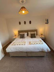 a bedroom with a large bed with two tables at The Lakes in Stockingford