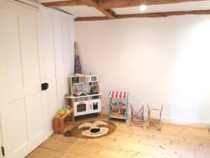 a room with a white wall and a toy stove at Grosse Charmante Wohnung in Erlach
