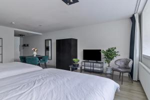 a bedroom with a bed and a flat screen tv at Central and light apartment in Rotterdam