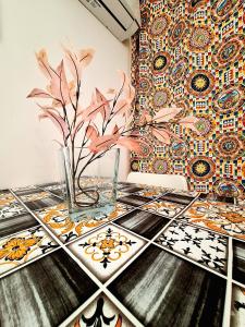 a table with a vase on it with a mosaic wall at Nata Sicula in Syracuse