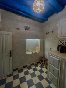 a room with a blue ceiling and a checkered floor at Dar Lalla Rahma in Essaouira +5 photos