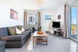 a living room with a couch and a tv at Fewo am Hochufer - erste Reihe in Ostseebad Sellin