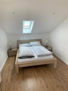 メーネゼーにあるGroße FeWo mit 2 Schlafzimmern in Körbeckeのベッドルーム1室(ベッド1台、ナイトスタンド2台、窓付)