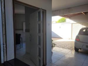 a door to a house with a car parked outside at Casa Compartilhada, com Suítes Privativas in São Raimundo Nonato