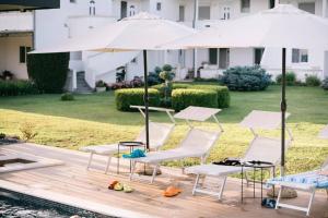 a group of chairs and umbrellas next to a pool at Sereno Village in Ulcinj