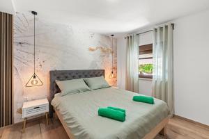 een slaapkamer met een bed met groene kussens erop bij Apartments Frama Poreč - Funtana in Funtana