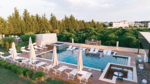 an outdoor swimming pool with umbrellas and chairs at Sereno Village in Ulcinj