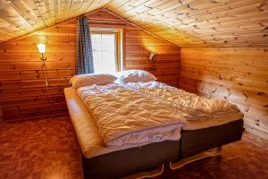 a large bed in a wooden room with a window at Nice Sirdal Bungalow in Ådneram in Ådneram