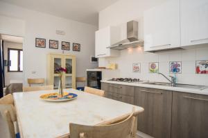 a kitchen with a table with a vase of flowers on it at B&B Villa Ziella in Portopalo