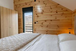 a bedroom with a bed and a wooden wall at Villa Vucje near Kolasin in Kolašin