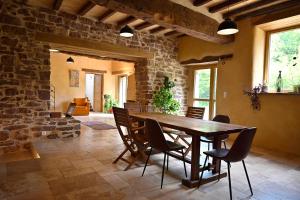 a dining room with a wooden table and chairs at Louzou Les Chambres Aux Loups in Iffendic