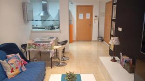 a living room with a couch and a table and a kitchen at El estudio de Inma in Burriana