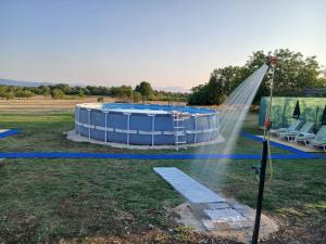 a pool with a water sprinkler in a field at Zavičajna kuća Šakota - Kozice in Stolac