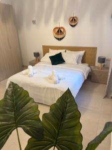 a bedroom with a bed with a large green plant at The Fifth Penthouse - 3 Large Bedrooms in Il-Gżira