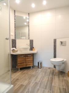 a bathroom with a sink and a toilet and a mirror at Karins Pension in Lampertheim