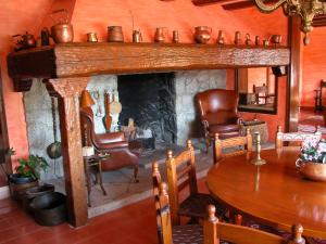 a living room with a fireplace and a table and chairs at Masia Vista Hermosa in Vallromanes