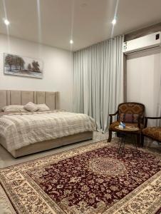 una camera da letto con un letto, una sedia e un tavolo di شقة نوريلا a Riyad
