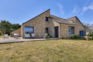 a brick house with a patio and a yard at Vue mer et acces plage direct pour 11 personnes in Saint-Gildas-de-Rhuys